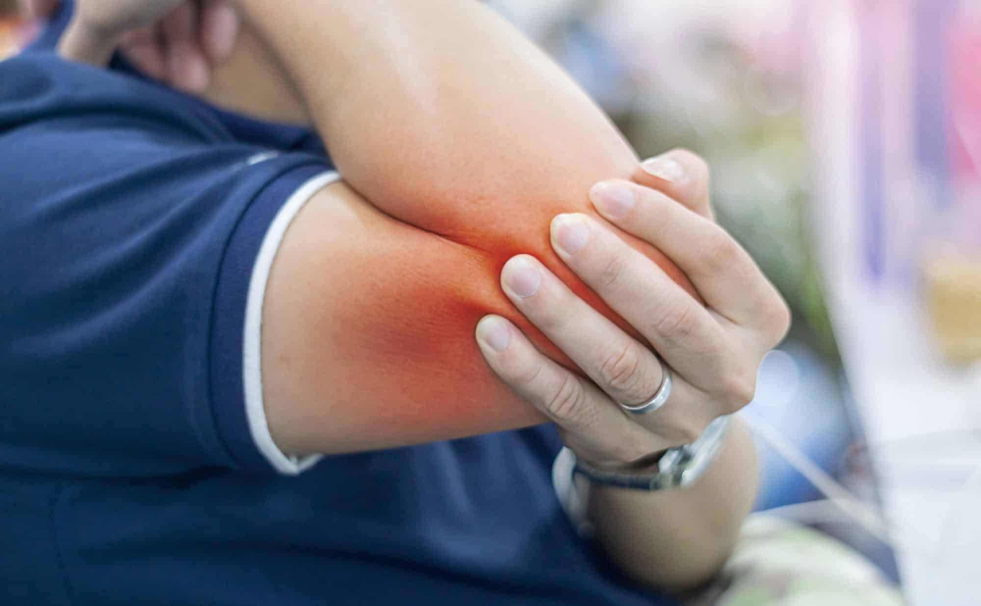 Businessman suffering from elbow pain at office